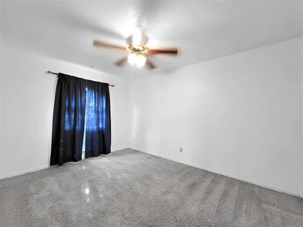 an empty room with closet and a chandelier fan