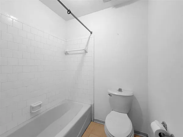 a white toilet sitting next to a bath tub