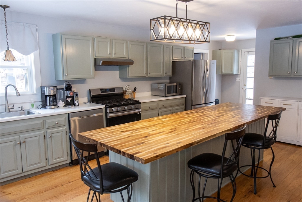 20 Paige Hill Road Brimfield, MA 01010 - Photo 11 of 40 a kitchen with stainless steel appliances granite countertop a kitchen island hardwood floor sink stove dining table and chairs