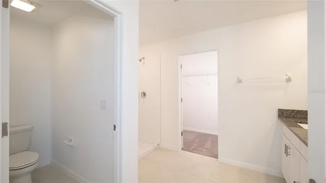 a white toilet sitting next to a white cabinet