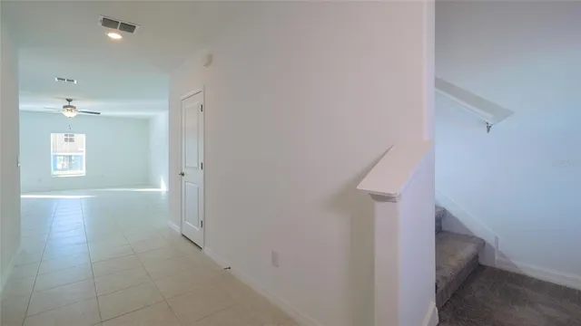 a view of hallway with stairs and wooden floor