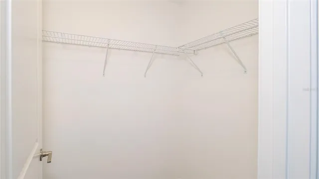 an empty room with chandelier fan