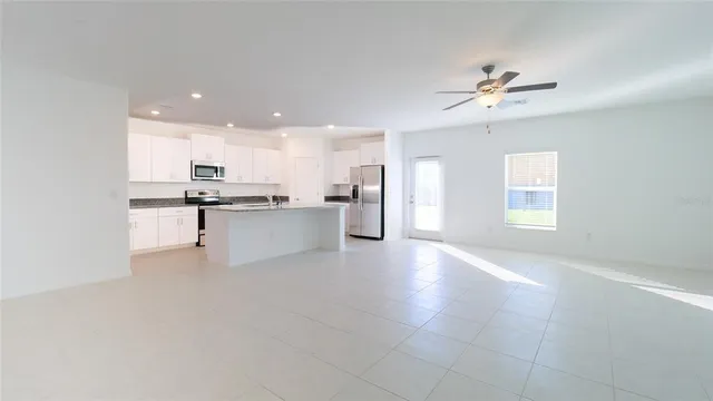 a view of a kitchen with a sink a refrigerator and window