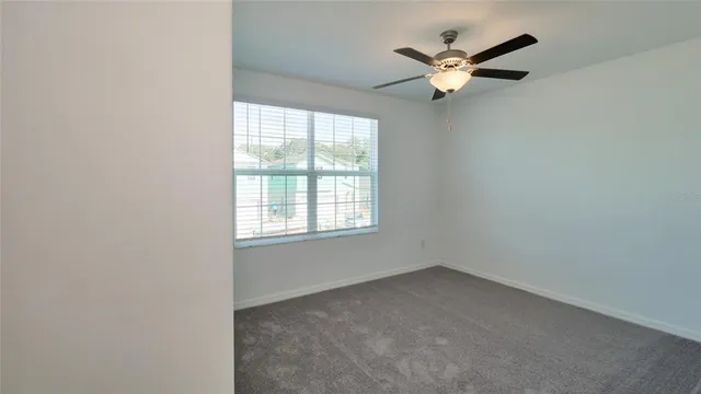 an empty room with a chandelier fan