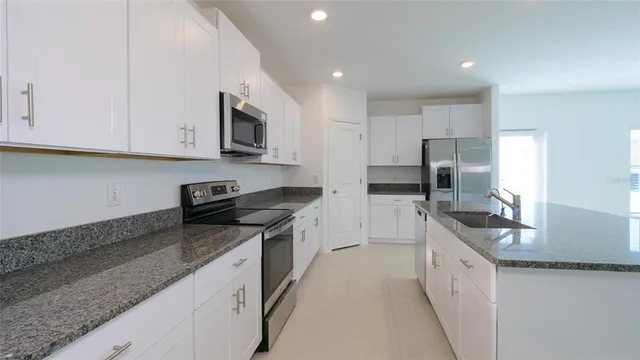 a kitchen with stainless steel appliances granite countertop a sink stove microwave and cabinets