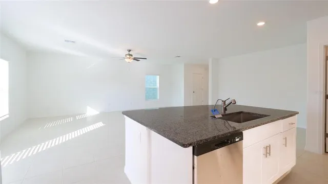 a kitchen with a sink a counter space and a refrigerator
