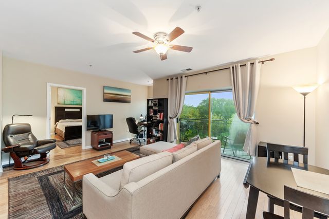 a living room with furniture ceiling fan and a window