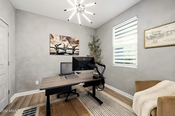 a view of a workspace with furniture and a window