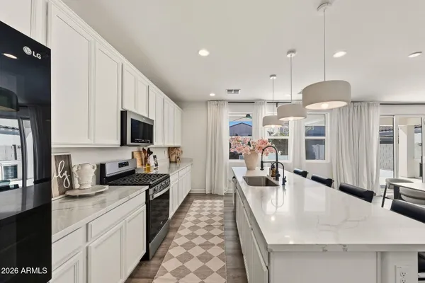 a kitchen with stainless steel appliances granite countertop a sink a stove and a refrigerator