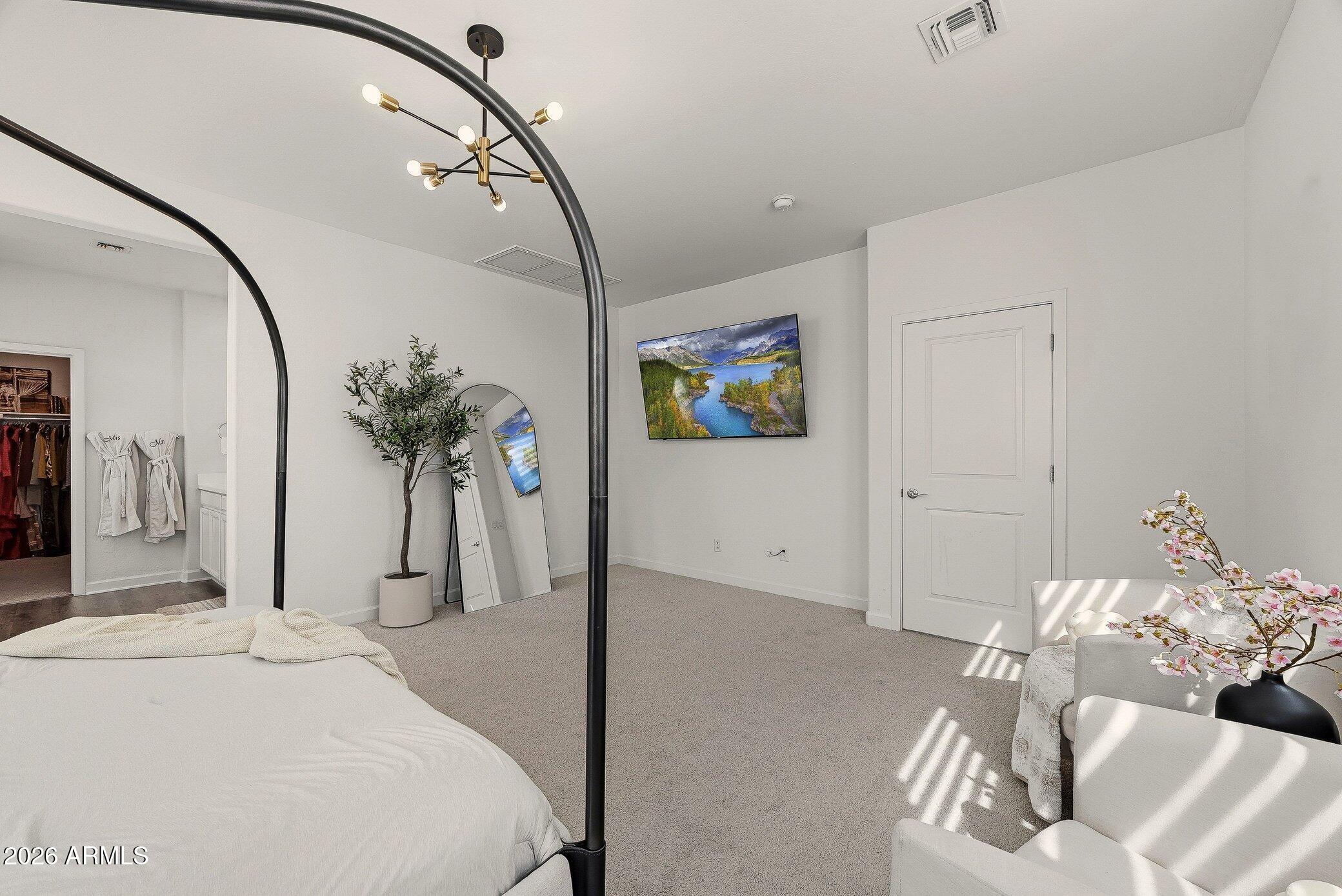 35032 North Barrel Road Queen Creek, AZ 85144 - Photo 25 of 40 a bedroom with a bed and a chandelier