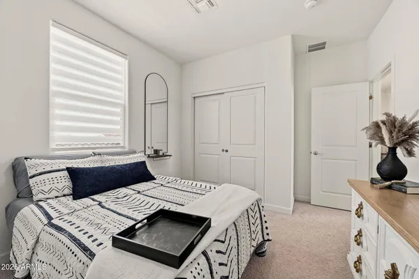 a bedroom with a bed and with a white cabinet