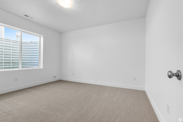 43 South Crimson Way, Unit 311 Mapleton, UT 84664 - Photo 23 of 28 Bright room featuring a large egress window, plush neutral-toned carpeting, and a flush-mount ceiling light fixture