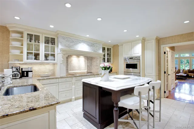 a kitchen with a sink stove and white cabinets with wooden floor