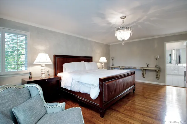 a spacious bedroom with a bed and wooden floor