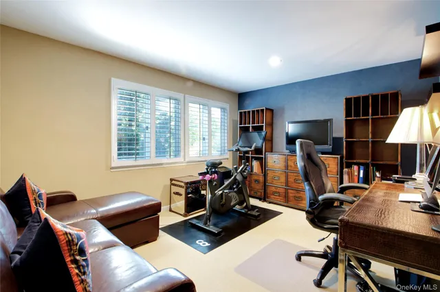 a view of a workspace with furniture and a window