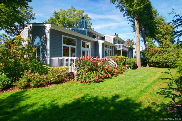 a view of a house with brick walls and a yard with plants