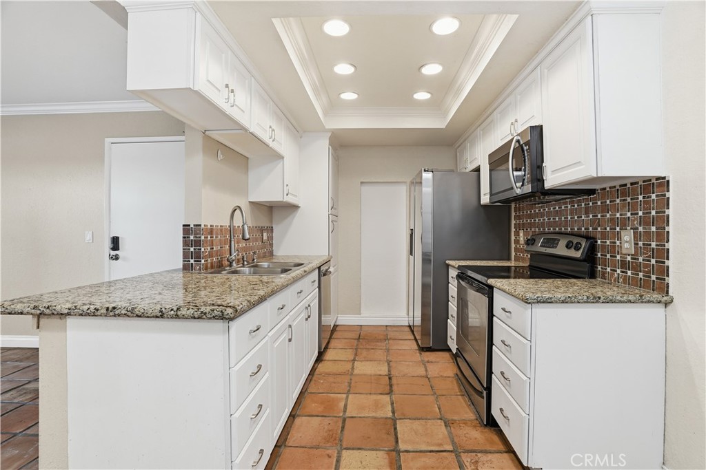 20702 El Toro Road, Unit 231 Lake Forest, CA 92630 - Photo 21 of 36 a kitchen with a sink stove and cabinets