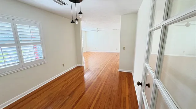 a view of a hallway with wooden floor and staircase