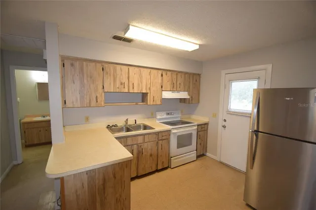 a kitchen with a stove a refrigerator and a sink
