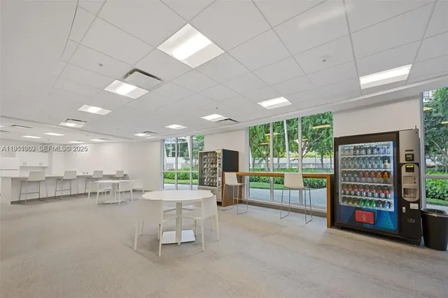 a room with lots of table chair and a large window