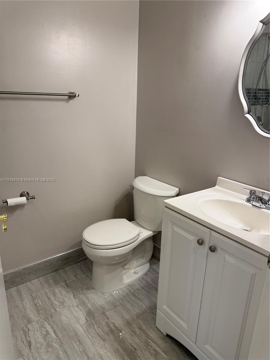 17449 Southwest 143rd Place Miami, FL 33177 - Photo 12 of 19 a white toilet sitting next to a bathroom sink