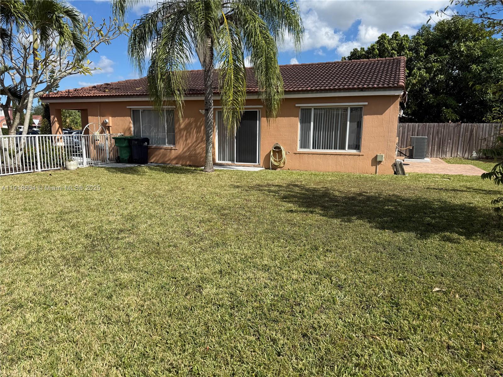 17449 Southwest 143rd Place Miami, FL 33177 - Photo 16 of 19 a view of a house with backyard and a tree