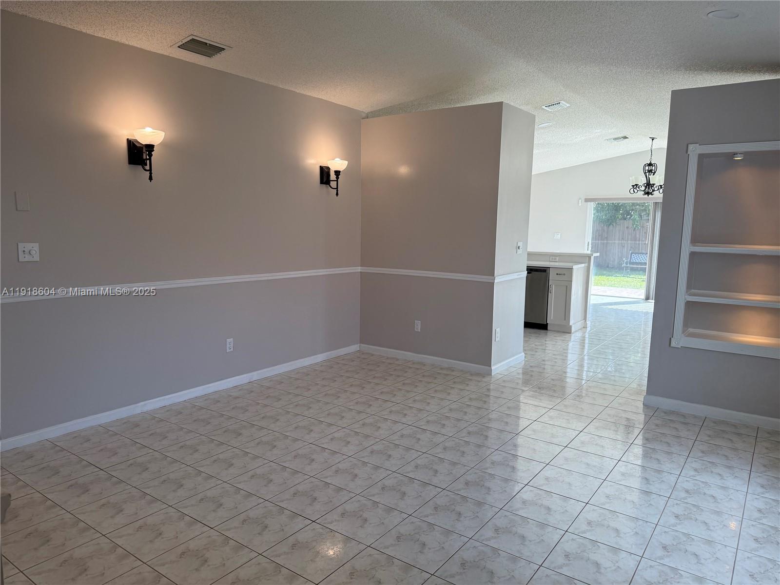 17449 Southwest 143rd Place Miami, FL 33177 - Photo 2 of 19 an empty room with kitchen view and windows