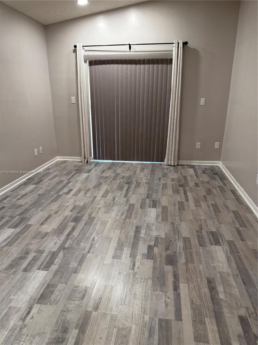 17449 Southwest 143rd Place Miami, FL 33177 - Photo 8 of 19 a view of an empty room with wooden floor