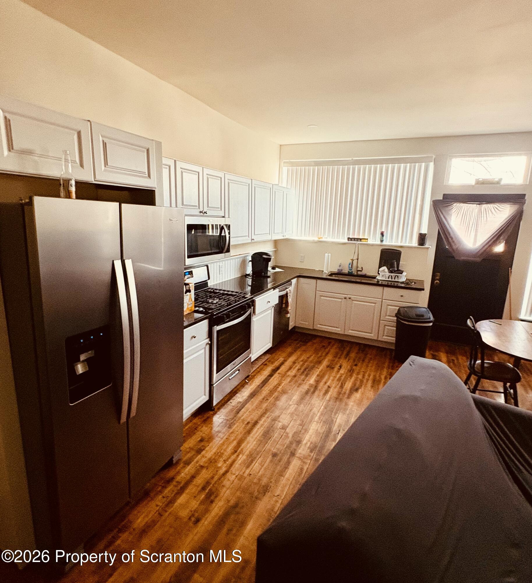 a kitchen with stainless steel appliances granite countertop a refrigerator a stove a sink dishwasher and wooden cabinets