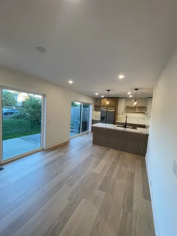 a view of kitchen and hall with wooden floor