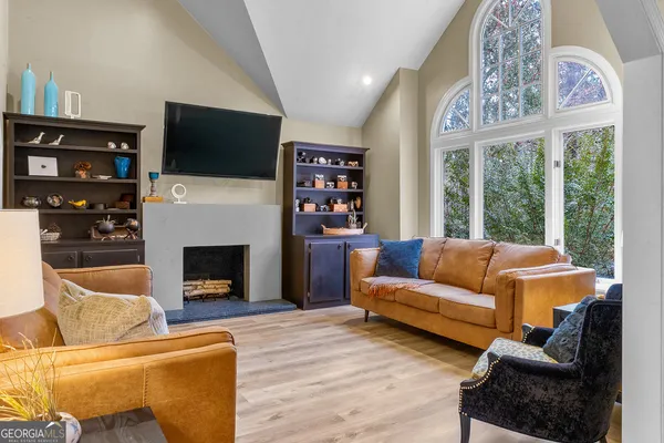 a living room with furniture a flat screen tv and a fireplace