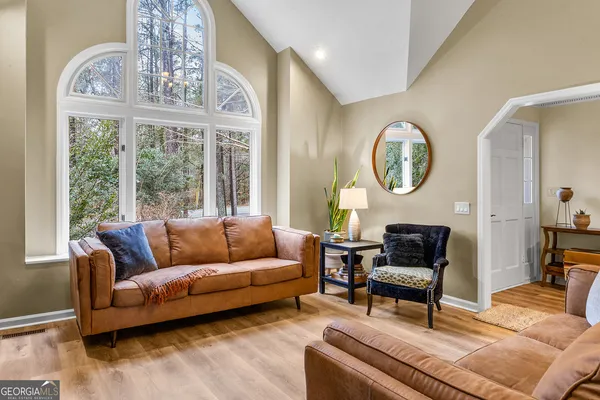 a living room with furniture a clock and a large window