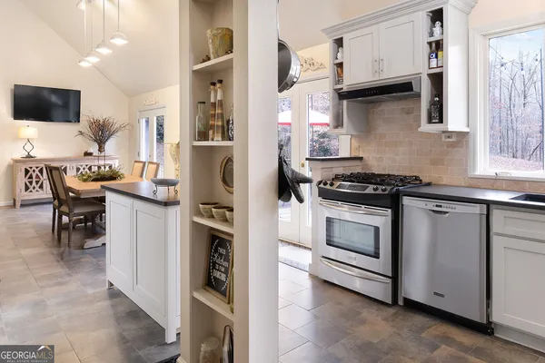 a kitchen with stainless steel appliances a stove a sink and a refrigerator