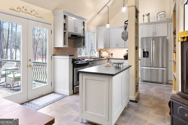 a kitchen with stainless steel appliances granite countertop a refrigerator a stove and a sink