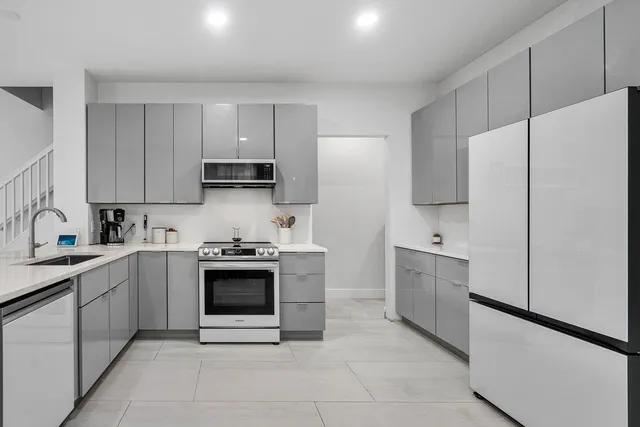 a kitchen with stainless steel appliances white cabinets and a sink