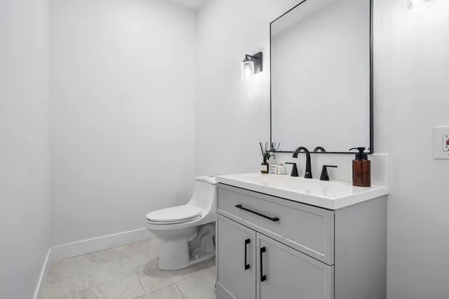a bathroom with a sink toilet and a mirror