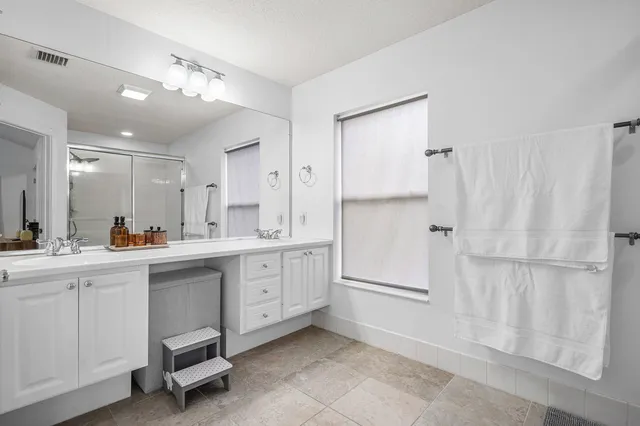 a kitchen with white cabinets and sink
