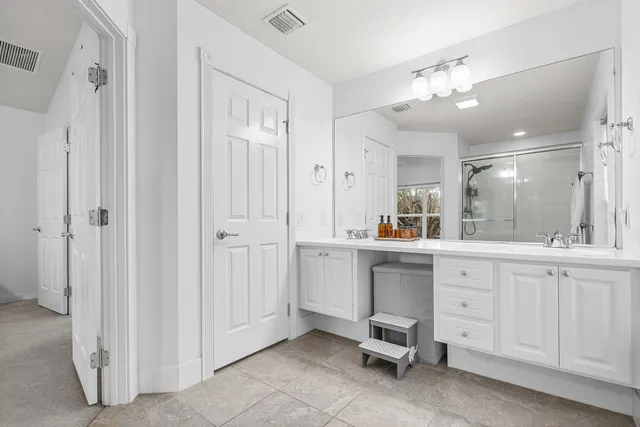 a large white kitchen with a sink and dishwasher