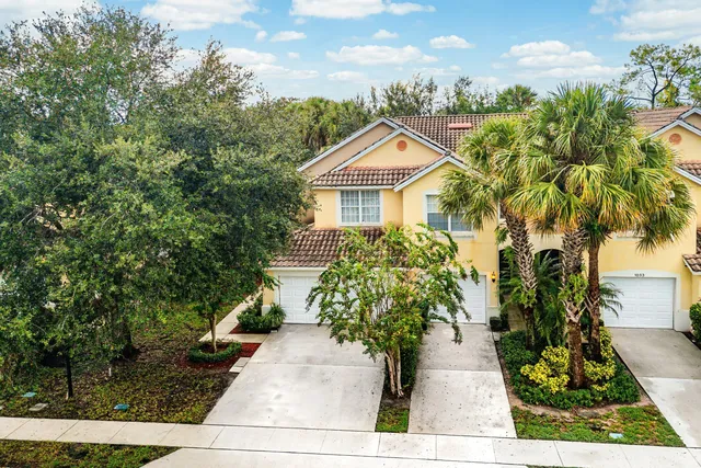 a front view of a house with a yard and potted plants