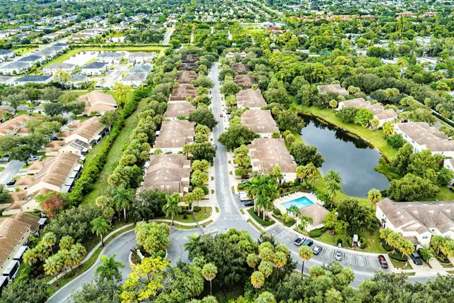 an aerial view of residential houses with outdoor space and trees all around