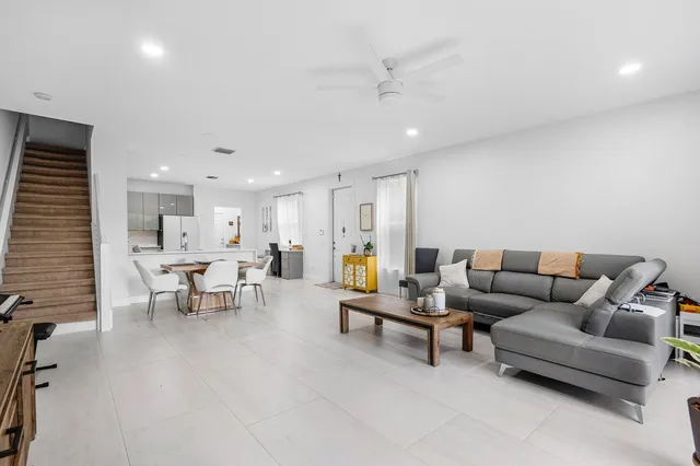 a living room with furniture and view of kitchen