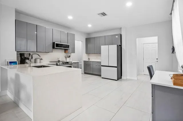 a kitchen with kitchen island a refrigerator sink and cabinets