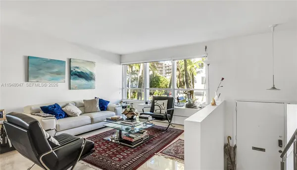 a living room with furniture and large windows