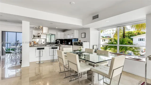 a kitchen with stainless steel appliances kitchen island granite countertop a table and chairs
