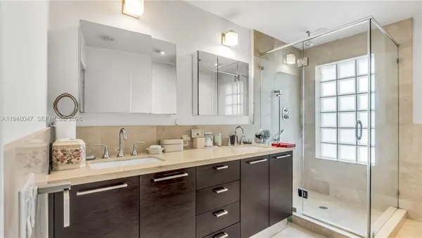 a bathroom with a sink mirror and a shower
