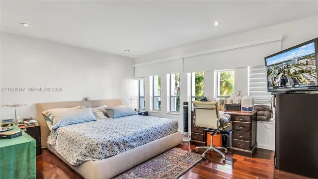 a bedroom with a bed a table and a flat screen tv
