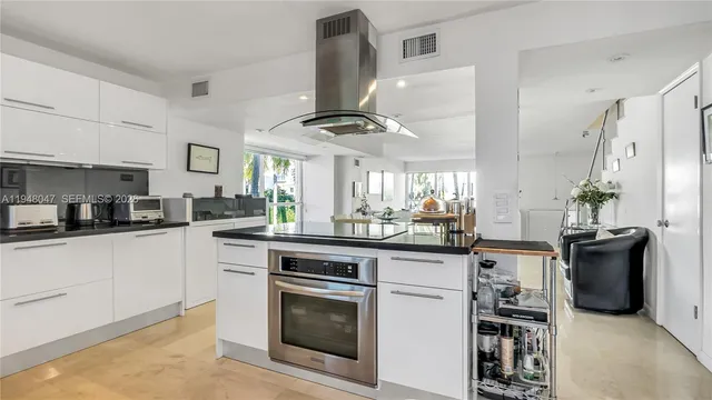 a kitchen with white cabinets and stainless steel appliances