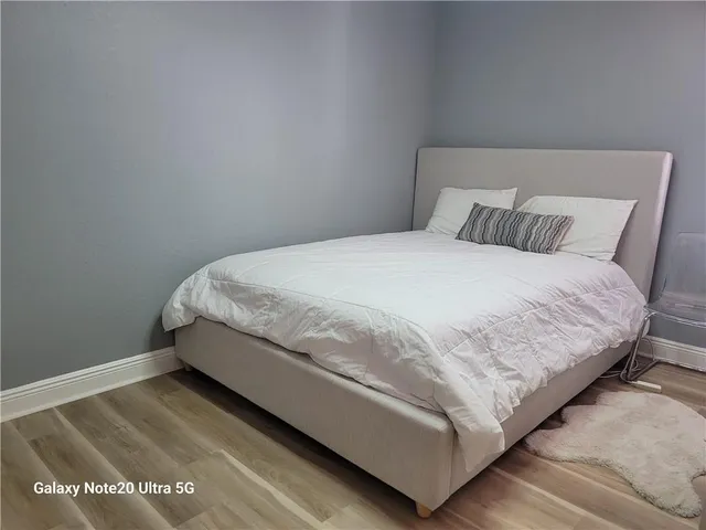 a large bed sitting in a bedroom next to a window