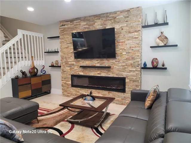 a living room with furniture a flat screen tv and a fireplace