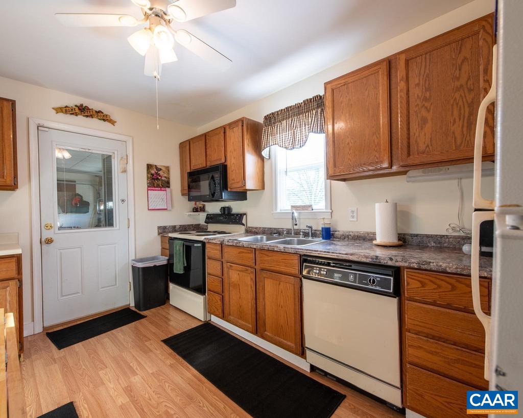 3483 West River Road Scottsville, VA 24590 - Photo 20 of 33 a kitchen with stainless steel appliances granite countertop a sink cabinets and wooden floor